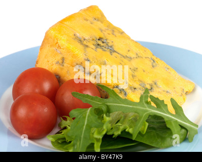 Un cuneo di freschi colori blu Shropshire formaggio con una insalata di pomodori ciliegini e Rucola contro uno sfondo bianco con n. di persone Foto Stock