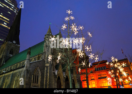 Le luci di Natale al di fuori di Cristo la Chiesa cattedrale nel centro di Montreal. Situato nel cuore del centro commerciale e dello shopping di Montreal, l'edificio neo-gotico fu completata nel 1859 e fu progettata dall'architetto britannico Frank Wills. Foto Stock