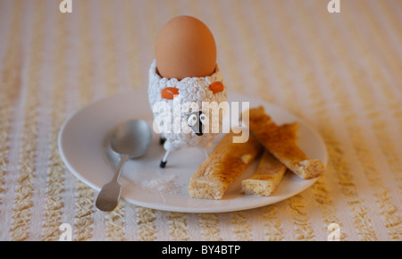Bambini uovo di pecora cup con uova sode e soldati imburrato Foto Stock