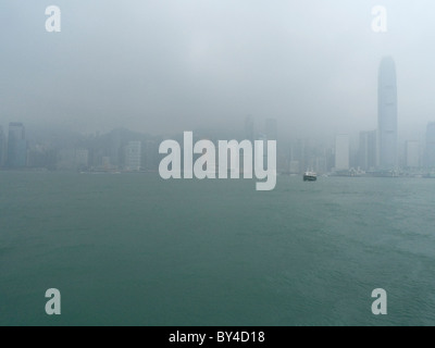 Edifici a scomparsa dalla nebbia e cloud, del porto di Victoria e di Hong Kong Foto Stock
