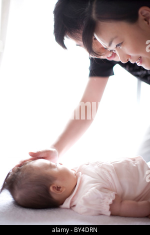 I genitori guardare la bambina dormire Foto Stock
