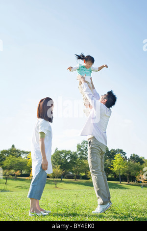 Padre sollevando la figlia Foto Stock