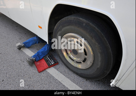 Mechanic sotto un bus in un garage Foto Stock