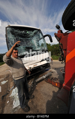 Distrutto con bus in frantumi il vetro del parabrezza dopo un incidente di macchina che viene tirata da un carrello di traino Foto Stock