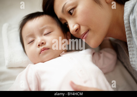 Madre Guarda Baby Boy Sleeping Foto Stock