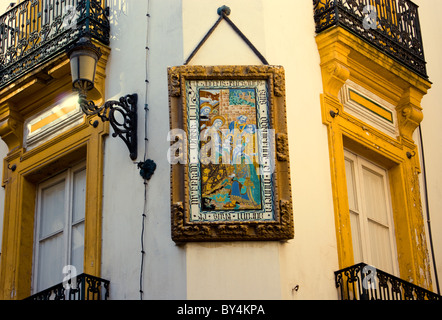 Piastrella religiosa tra due balconi a Siviglia Foto Stock