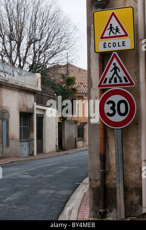 Segnaletica di avvertimento di una limitazione di velocità a 30 km/h, un attraversamento pedonale e una scuola in un villaggio francese. Foto Stock