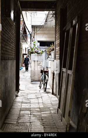 Cina, Xian: Vicolo nel Quartiere Musulmano di vecchi Xian con un uomo proveniente da home shopping e una bicicletta parcheggiata. Foto Stock