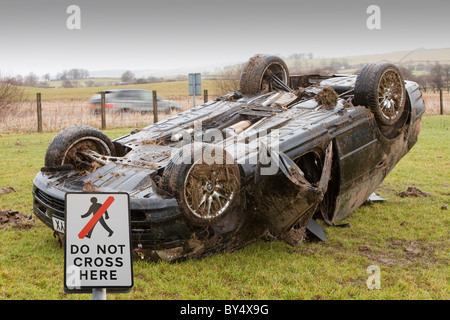 Una BMW auto si è schiantato sul suo tetto nel mezzo di un campo dopo aver lasciato la strada ad alta velocità su un66 Near Keswick Cumbria Regno Unito Foto Stock