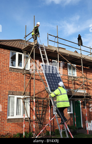 Installazione di Photo Voltaic pannelli solari sul tetto di una casa nazionale all'interno di Washington, North East England, Regno Unito Foto Stock