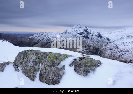 Vista verso il luccio o Blisco dalla band su Bowfell sul grigio di una giornata invernale nel Lake District inglese Foto Stock