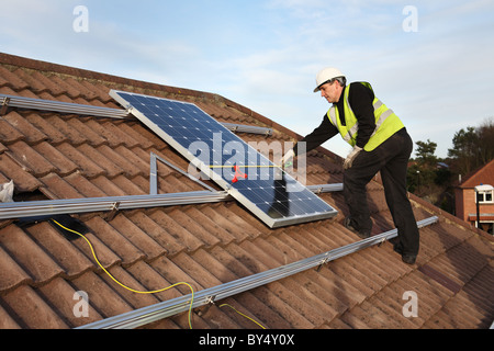 Installazione di Photo Voltaic pannelli solari sul tetto di una casa nazionale all'interno di Washington, North East England, Regno Unito Foto Stock