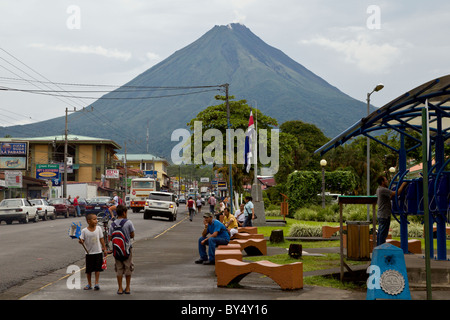 La città di La Fortuna de San Carlos con il Vulcano Arenal incombente in background, Alajuela in Costa Rica. Foto Stock