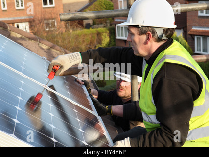 Installazione di Photo Voltaic pannelli solari sul tetto di una casa nazionale all'interno di Washington, North East England, Regno Unito Foto Stock