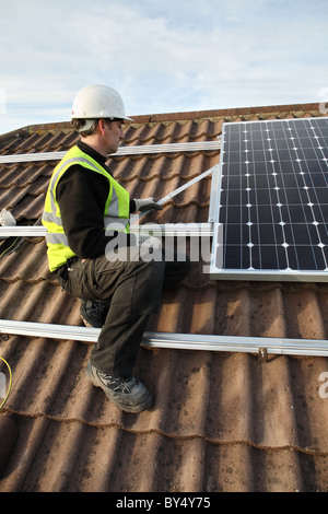 Installazione di Photo Voltaic pannelli solari sul tetto di una casa nazionale all'interno di Washington, North East England, Regno Unito Foto Stock