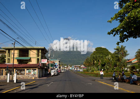 Mattina nubi oscure il cono superiore dell'incombente Vulcano Arenal in La Fortuna de San Carlos, Alajuela in Costa Rica. Foto Stock