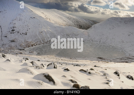 Inverno vista su congelati Grisedale Tarn, Fairfield e sandalo sedile nel Lake District inglese. Preso da Dollywagon Pike Foto Stock