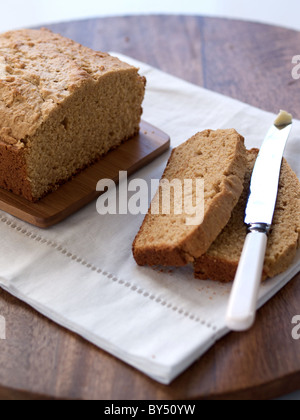 Pane alla banana raffreddamento su tagliere con burro Foto Stock