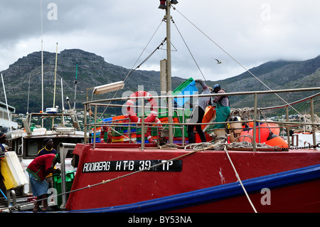 Fisherman caricare una barca da pesca al porto. Cape Town, Sud Africa. Foto Stock