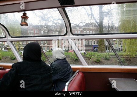 I turisti che guarda fuori dall'interno barca a Amsterdam, Olanda Foto Stock