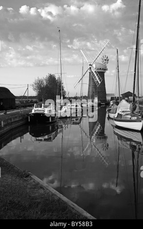 Un bianco e nero di scena Horsey Mill e barche ormeggiate in Horsey Dyke su il Parco Nazionale Broads del Norfolk, Inghilterra, Regno Unito. Foto Stock