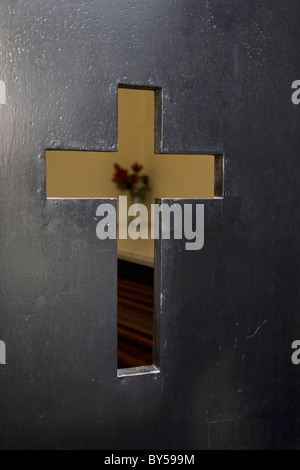 Dettaglio di un taglio a croce-out nella porta di una chiesa Foto Stock