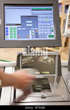 Un cassiere la scansione di generi alimentari in un supermercato, messa a fuoco a portata di mano Foto Stock