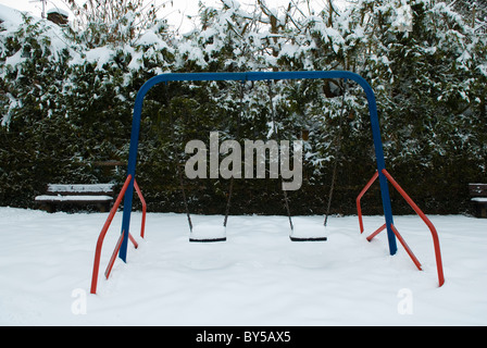 Coperta di neve per bambini altalene Foto Stock