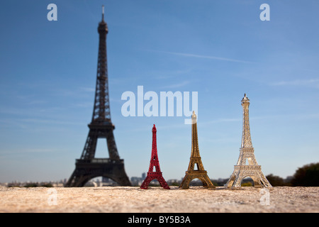 Tre Torre Eiffel replica negozio di souvenir accanto alla vera Torre Eiffel, la messa a fuoco su oggetti in primo piano Foto Stock