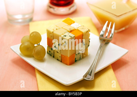 Cubo di formaggio con coulis di uva. Ricetta disponibile. Foto Stock