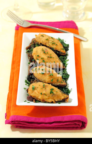 Cozze ripiene su spinaci e Funghi Ricetta disponibile. Foto Stock