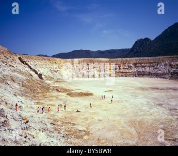 I turisti attraversano la crosta di zolfo del cratere Stefanos Mt Polyvotis sull'isola vulcanica isola di Nissiros nel Dodecanneso Foto Stock