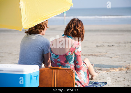 Una giovane coppia in spiaggia, vista posteriore Foto Stock