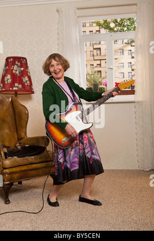 Un senior donna suonando una chitarra elettrica Foto Stock