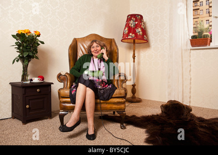 Un senior donna al telefono di casa Foto Stock