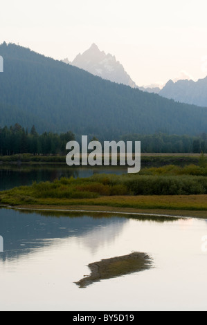 Mt. Picchi Teewinot su una cresta e riflette ancora in acque della lanca di piegare al tramonto Foto Stock