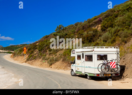 Camper con la bici sul rack moto parcheggiata su una strada di montagna nel Parco Nazionale di Picos de Europa in Cantabria in Spagna settentrionale Foto Stock