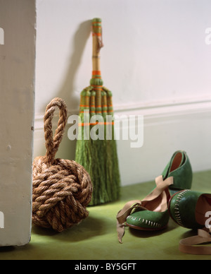 Close-up di fune porta-stop accanto a scopa verde e scarpe verde Foto Stock