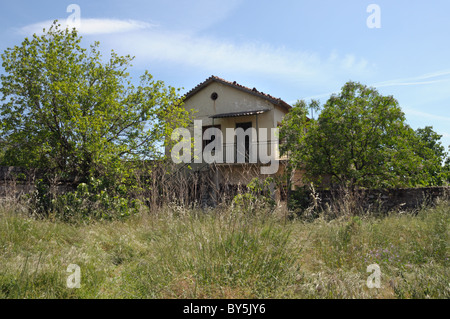 Abbandonato casa rurale ed incolto giardino. Foto Stock