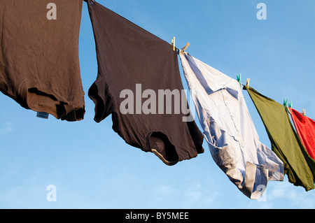 Maglietta e t-shirts appeso sulla linea di lavaggio in estate il sole Foto Stock