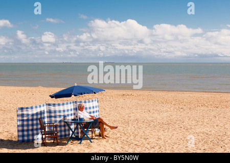 Un uomo relax sulla spiaggia in Southwold , Suffolk , Inghilterra , Inghilterra , Regno Unito Foto Stock