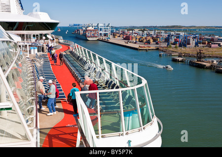 La nave di crociera i passeggeri si mescolano sul ponte accanto alla nave container essendo caricato nel porto di Boston, Boston, Massachusetts Foto Stock