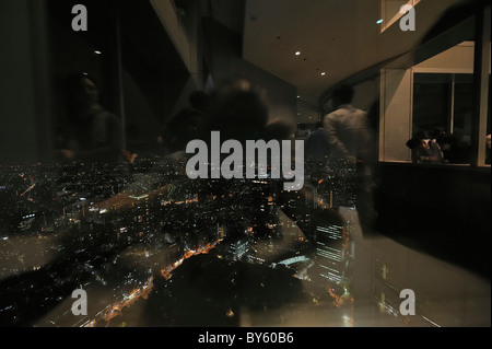 Lo skyline di Tokyo di notte e riflessi dall'interno visto presso il Governo Metropolitano di Tokyo edificio uffici, Tokyo, Giappone Foto Stock