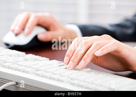 La foto in orizzontale di un segretario le mani sopra i tasti e mouse vicino da Foto Stock