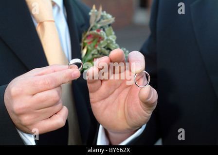 Lo sposo e il miglior uomo tenendo gli anelli di nozze Foto Stock
