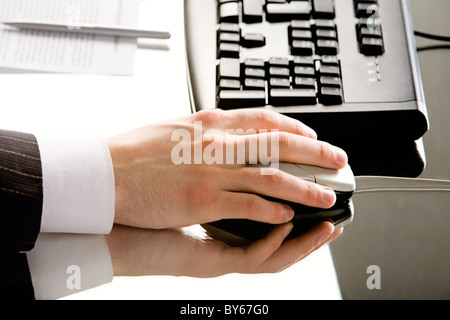 Immagine della mano con il mouse del computer posto su una tavola di lavoro Foto Stock