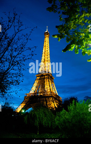 Luci dorate illuminate dalla Torre Eiffel di notte Parigi Francia // PARIGI, Francia - la Torre Eiffel è illuminata con luci dorate contro il cielo notturno di Parigi, Francia. Questa iconica torre a reticolo di ferro, situata sul campo di Marte, è stata progettata dall'azienda Gustave Eiffel per l'esposizione universale del 1889. Alto 330 metri (1.083 piedi) con la sua antenna, è un punto di riferimento importante nella capitale francese. Il suo brillante display crea un faro nel paesaggio notturno parigino. La torre è un'icona culturale globale e un simbolo della Francia. Foto Stock