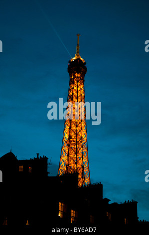 Torre Eiffel struttura in ferro laminato illuminata al tramonto Parigi Francia // PARIGI, Francia — la Torre Eiffel, una struttura a reticolo in ferro battuto, è illuminata e sagomata contro il crepuscolo cielo di Parigi, Francia. Le sue luci iniziano a brillare mentre il giorno passa alla notte sopra la città della luce. Progettato da Gustave Eiffel, questo iconico monumento è stato completato nel 1889 per l'esposizione universale. Alto 330 metri (1.083 piedi), è un'icona culturale globale e uno dei monumenti più visitati al mondo. È un punto di riferimento importante nella capitale francese, l'Île-de-France. Foto Stock