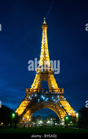 Torre Eiffel illuminata con fascio di luce di ricerca Parigi Francia // PARIGI, Francia - la Torre Eiffel è illuminata di notte con luci dorate e un'esposizione scintillante, con un prominente fascio di luce di ricerca dalla sua cima. Questa iconica torre reticolare in ferro battuto sul campo di Marte è un'icona culturale globale della Francia. Progettato da Gustave Eiffel, è stato costruito dal 1887 al 1889 per l'esposizione universale del 1889. Con un'altezza di 330 metri (1.083 piedi), inclusa la sua antenna, è stata la struttura artificiale più alta del mondo per 41 anni. Il suo spettacolo di luci notturne e il faro rotante trasformano la notte parigina Foto Stock