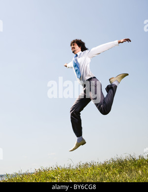 Ritratto di felice dipendente jumping e alzando le mani Foto Stock